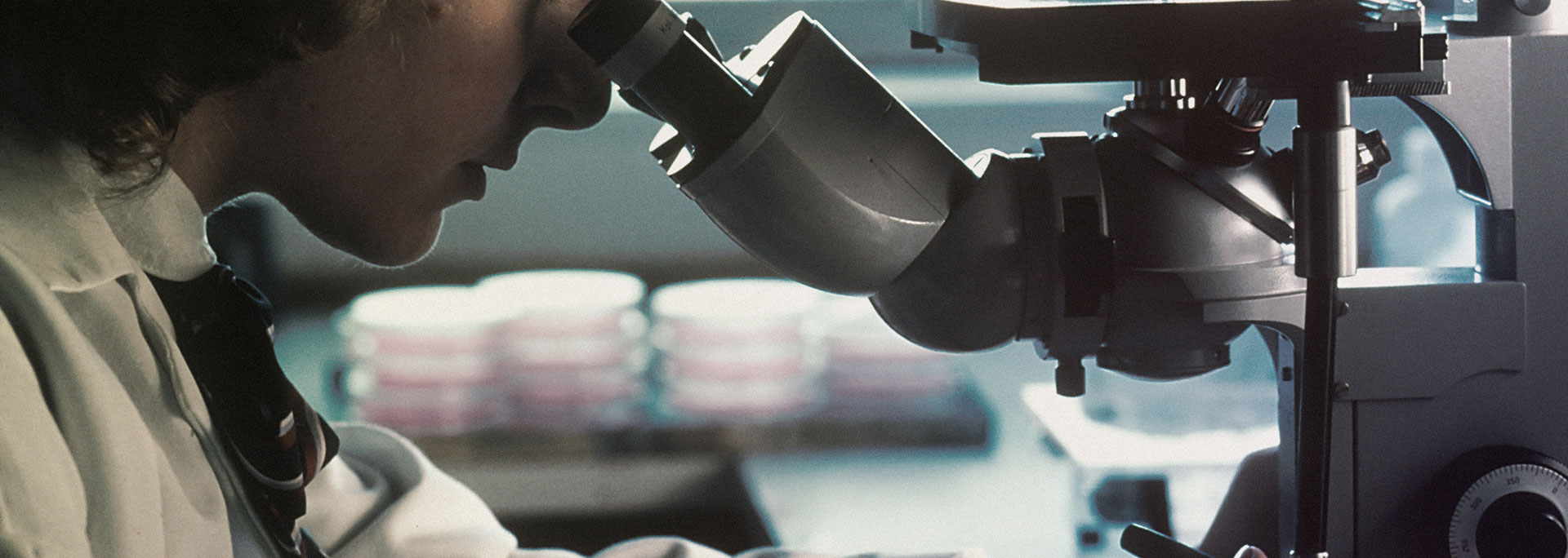Person using a microscope in a laboratory.